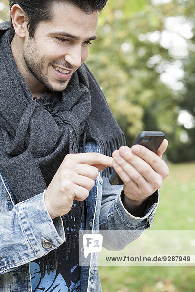 Young man using smartphone outdoors