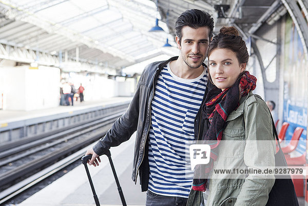 Couple with luggage on train platform