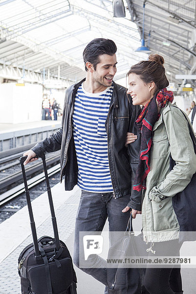 Paar mit Gepäck auf dem Bahnsteig