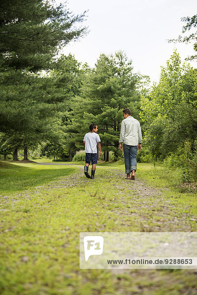 Two brothers walking on a country path.