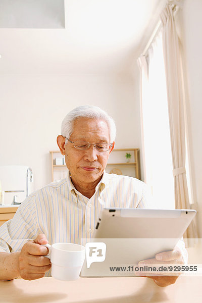 Senior adult Japanese man with tablet