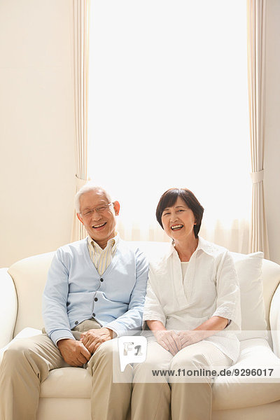 Senior adult Japanese couple on the sofa