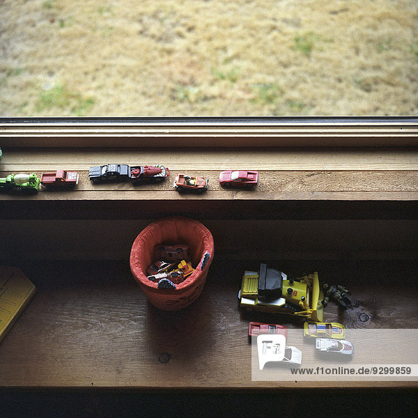 Eine Sammlung von Spielzeugautos auf einer Fensterbank