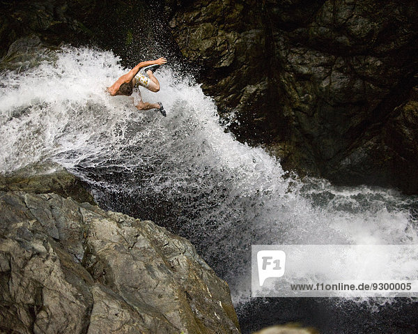 Mann springt zum Wasserfall  Lynn Canyon  Vancouver  Kanada