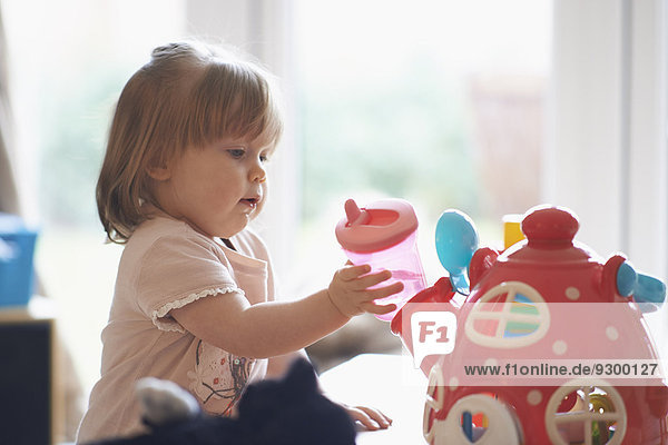 Kleines Mädchen spielt zu Hause mit Spielzeug
