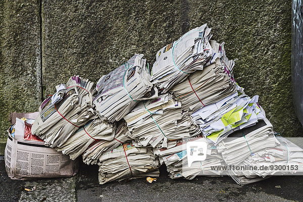 Bündel von alten Zeitungen gegen die Wand