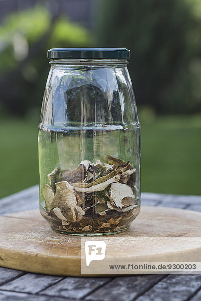 Getrocknete Pilze im Glas auf dem Tisch im Freien