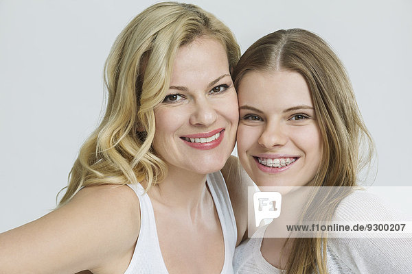 Porträt von glücklichen Freundinnen  die isoliert über weißem Hintergrund lächeln.
