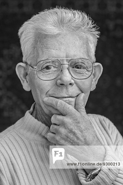 Nahaufnahme eines glücklichen Senioren mit Brille über schwarzem Hintergrund