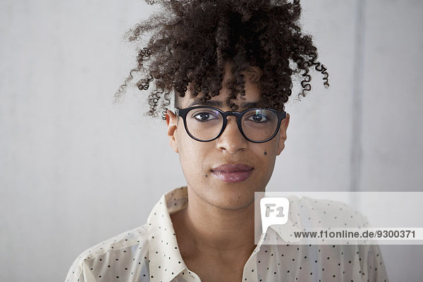 Porträt einer jungen Frau mit lockigem Haar zu Hause