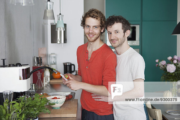 Portrait of loving gay couple in kitchen