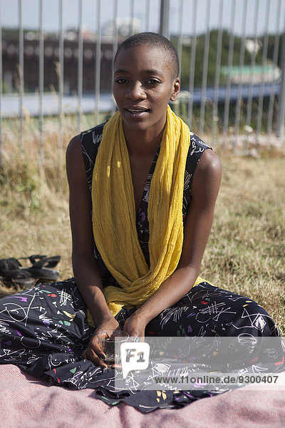 Porträt einer jungen Frau  die auf der Terrasse sitzt.