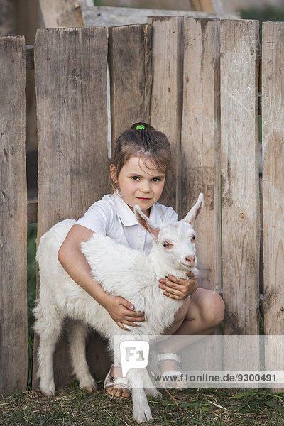 Porträt eines jungen Mädchens mit Ziegenbaby im Park