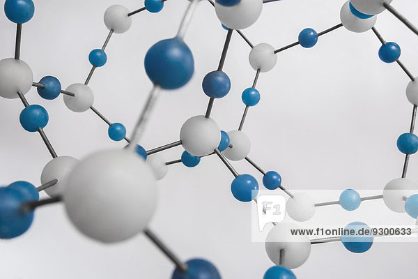 Blau-weiße Molekularstruktur vor weißem Hintergrund