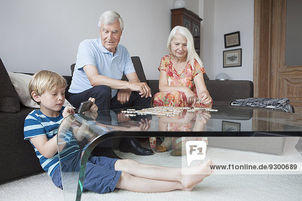 Großeltern und Enkel verbringen Freizeit im Wohnzimmer