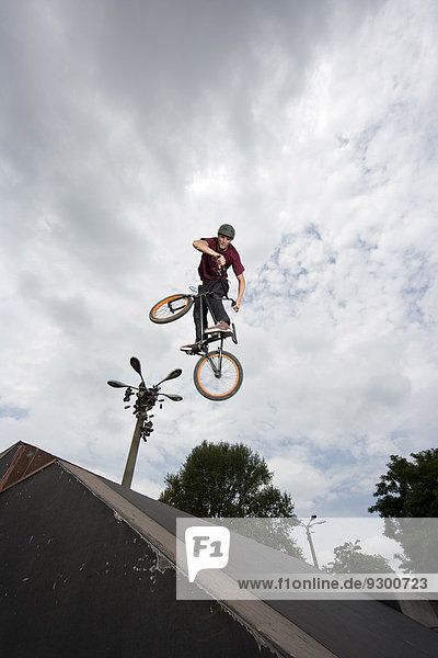 Ein junger Mann in der Luft  der einen Stunt auf einem BMX-Bike macht.