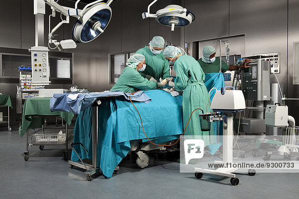Ärzte und Krankenschwestern  die einen Patienten im Operationssaal operieren