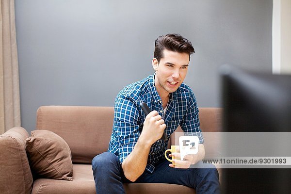 Young man watching TV in living room