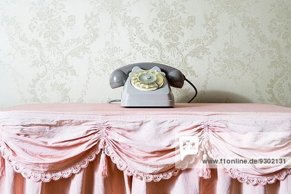Stilleben von Vintage-Telefon auf Rüschen-Tischdecke
