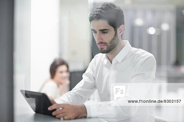 Männlicher Büroangestellter mit digitalem Tablett