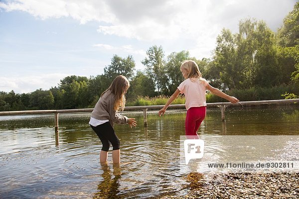 Two girls paddling in lake