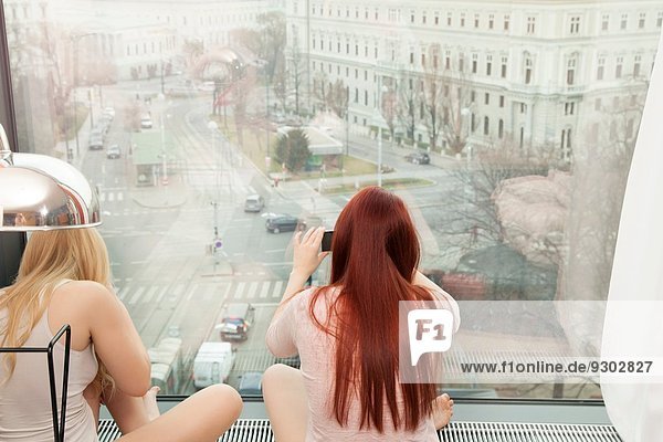 Junge Frau fotografiert am Hotelfenster mit Aussicht  Wien  Österreich