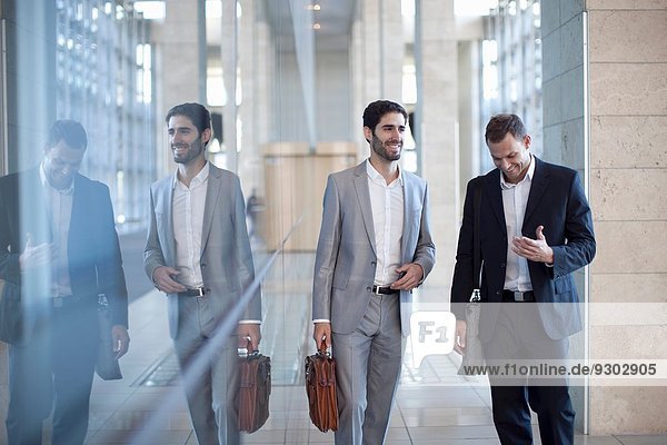 Zwei junge Geschäftsleute beim Spazierengehen und Plaudern im Konferenzzentrum