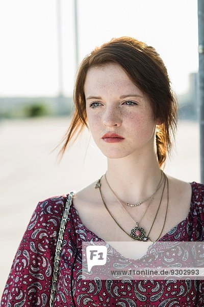 Portrait of serene young woman in empty parking lot
