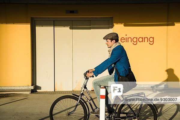 Junger Mann fährt mit dem Fahrrad durch die Stadt