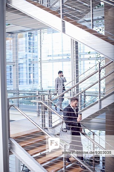 Zwei junge Geschäftsleute auf der Treppe des Konferenzzentrums