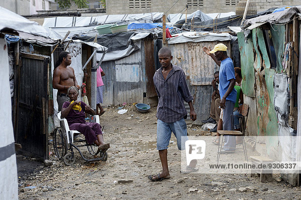 People and a sick woman in a wheelchair  Camp Icare  camp for earthquake refugees  Fort National  Port-au-Prince  Haiti