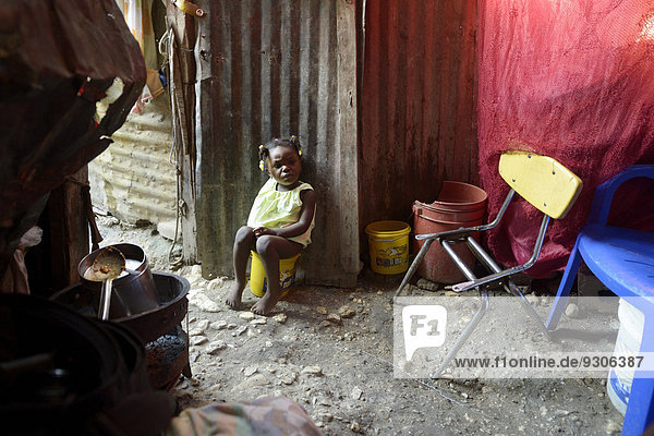 Girl  two years  using a plastic bucket as a toilet  Camp Icare  camp for earthquake refugees  Fort National  Port-au-Prince  Haiti