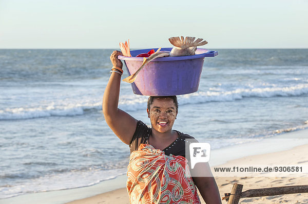 Madagassische Frau trägt Fisch in einer Wanne auf dem Kopf  Morondava  Provinz Toliara  Madagaskar