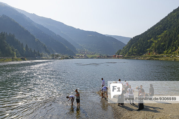 Tourists on the shore of lake Uzungöl village of Uzungöl Trabzon Province Pontic Mountains Black Sea Region Turkey