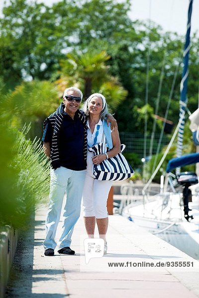Mature couple enjoying a stroll at a marina