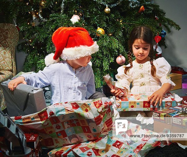 Kinder eröffnen Weihnachtsgeschenke