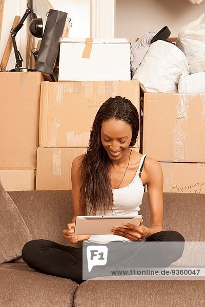 Frau in der Wohnung sitzend  umgeben von Kisten