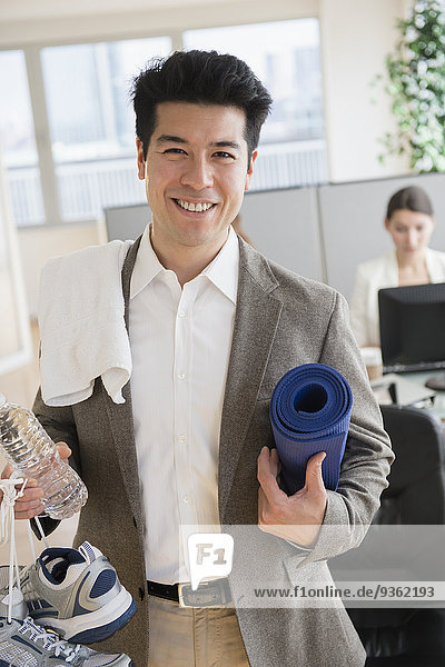 Businessman carrying workout gear in office