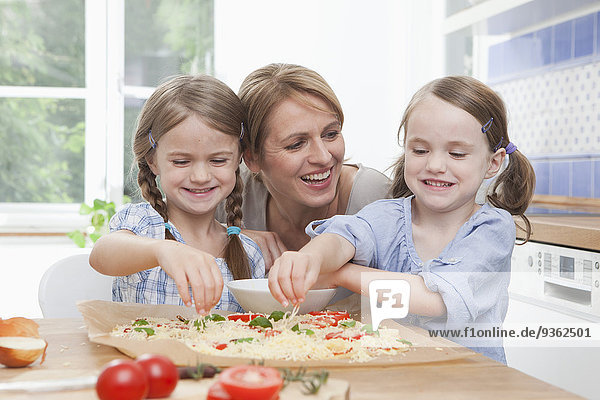 Germany  Munich  Mother with daughters (4-7) preparing food