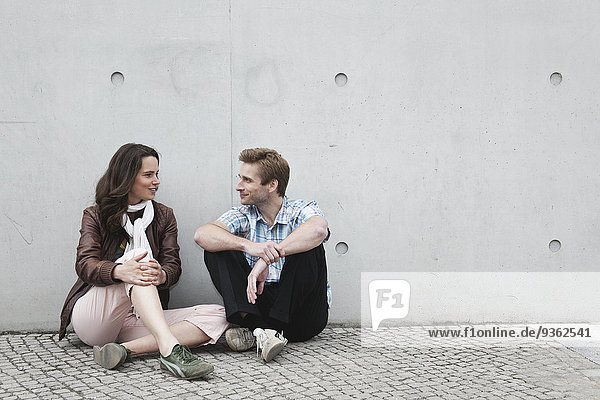 Deutschland  Berlin  Mann und Frau sitzen an der Wand
