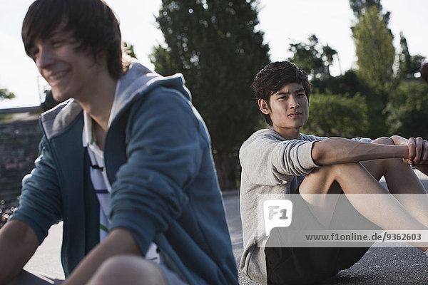 Germany  Berlin  Teenage boys sitting in playground