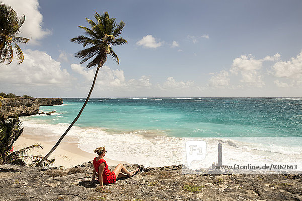 Karibik  Barbados  Bottom Bay  Frau an der Küste sitzend