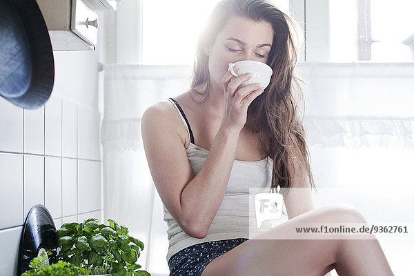 Portrait of young woman drinking tea in the morning