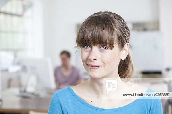 Portrait of smiling young woman in an creative office