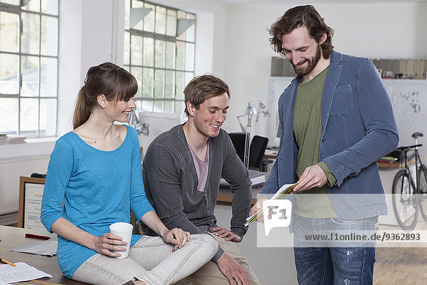 Three colleagues discussing in a creative office