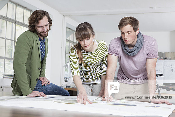 Drei Kollegen bei der Konzeption in einem Kreativbüro