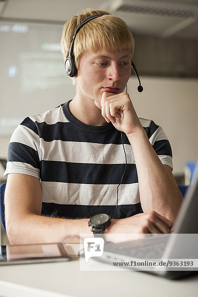 Vocational school student with headset in computer lab