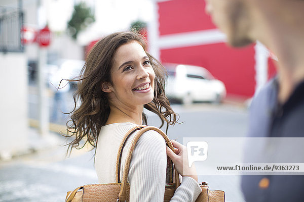 Porträt einer lächelnden Frau mit einem Freund auf der Straße