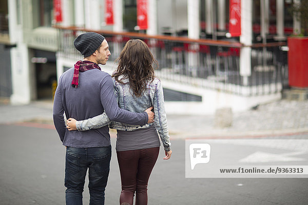 Young couple walking arm in arm on the street