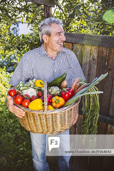 Deutschland  Nordrhein-Westfalen  Bornheim  Senior Mann mit Gemüsekorb